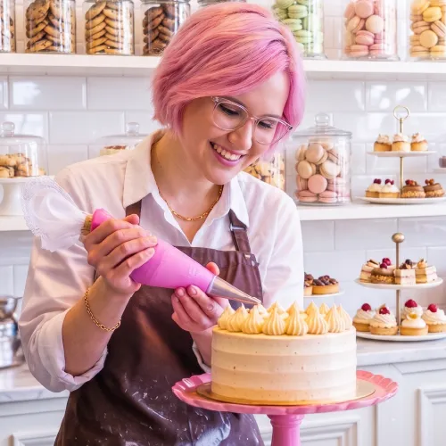 Paty decora un pastel en su repostería